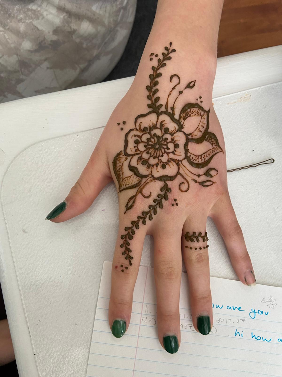 Small floral henna spray on a child's hand